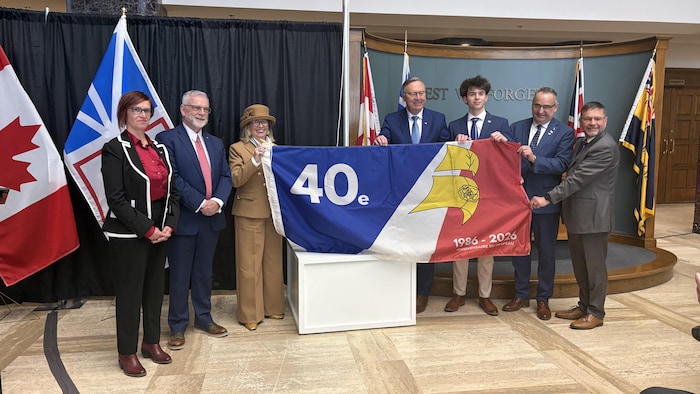 Le drapeau franco-terre-neuvien-et-labradorien avec plusieurs dignitaires.