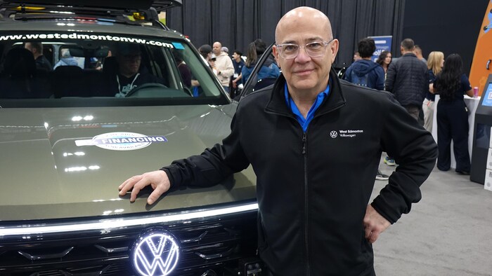 Un homme se place devant une voiture.