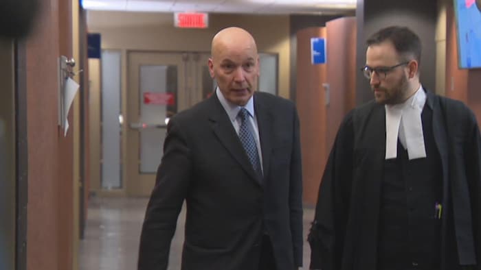 Frank Zampino marche dans un corridor du palais de justice de Montréal en compagnie d'un avocat.