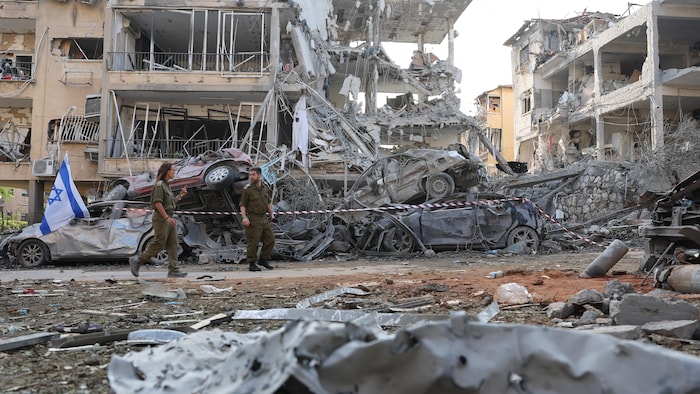 Des soldats israéliens inspectent un site touché par un missile.