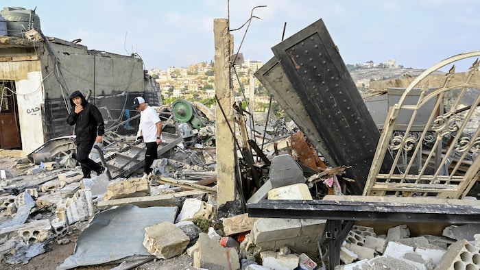 Des personnes évaluent les dégâts sur le tract d'une frappe aérienne israélienne dans le colony de Toura, dans le sud du Liban, le 6 novembre 2025.