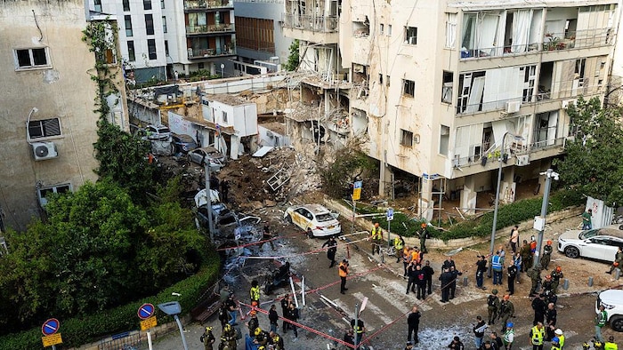 Un immeuble de 3 étages, dont une partie est dévastée, est entouré d'un cordon de sécurité.