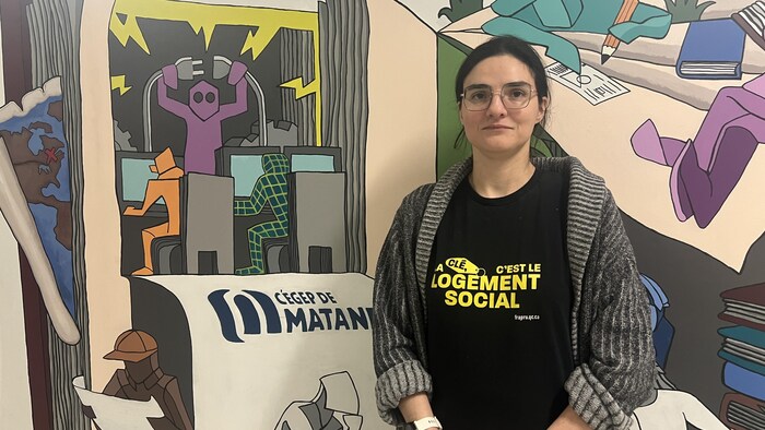 Elle porte un chandail où est inscrit «La clé, c'est le logement social».