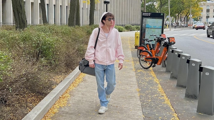 Un homme qui marche sur le trottoir.