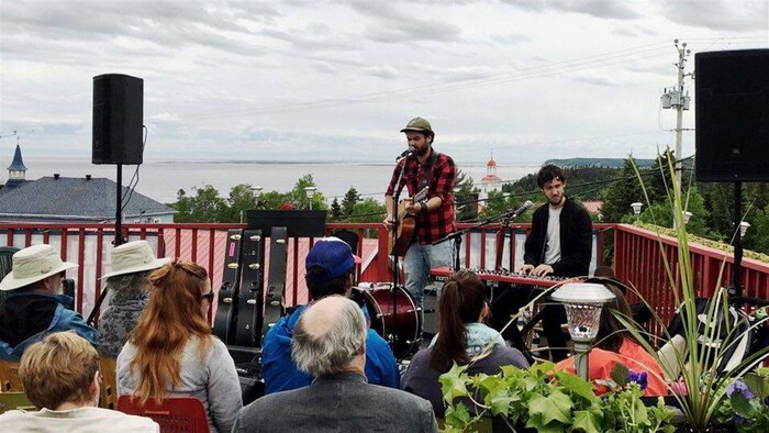 Les artistes Fred Labrie et Eric Charland en prestation sur une terrasse au Festival de la chanson de Tadoussac