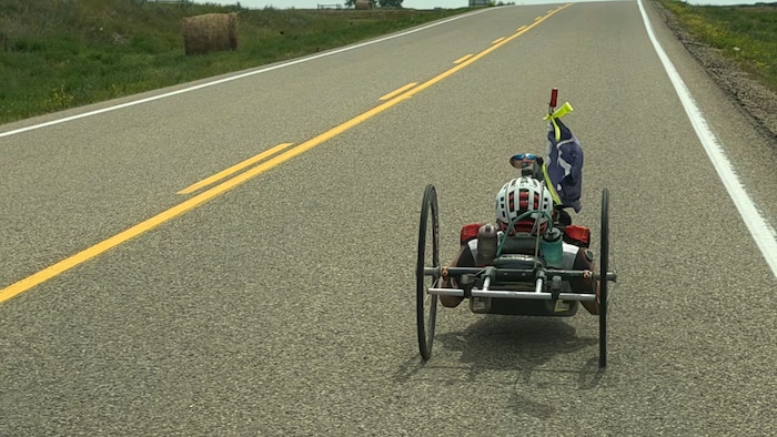 Une personne sur un vélo à main roule sur une route.