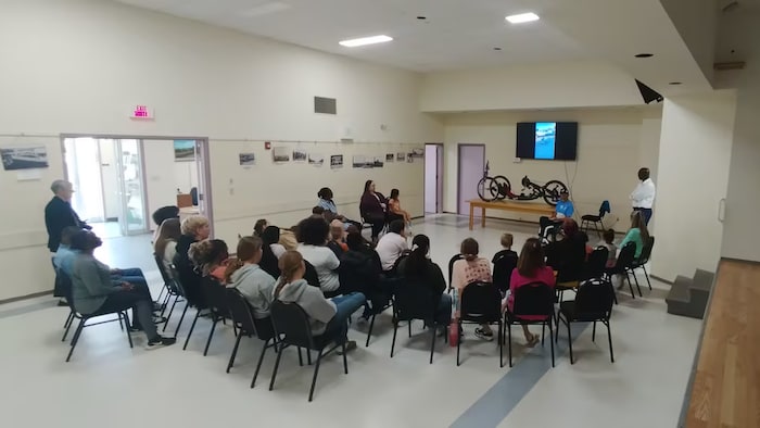 Des personnes présentes dans une salle de classe.