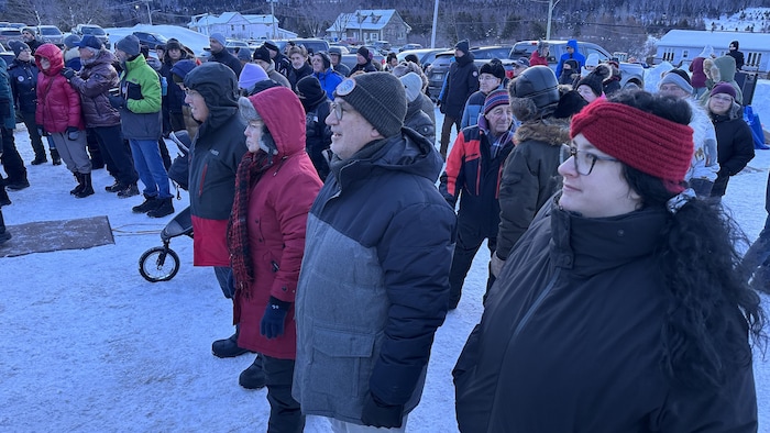 Des gens debout en hiver au lever du soleil.