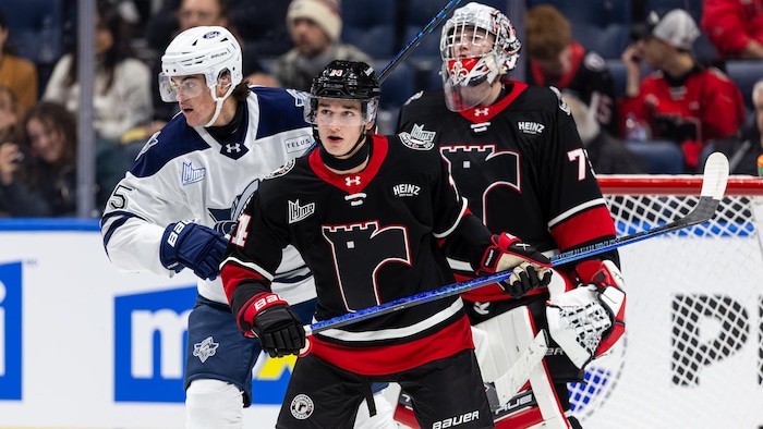 Trois joueurs de hockey sur la glace.