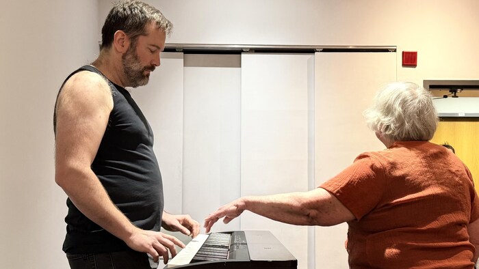 Les comédiens à l'oeuvre devant un piano.