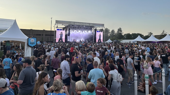 Fredz performe sur une scène devant un public de plusieurs milliers de personnes.