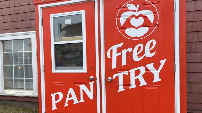 Deux portes peintes en rouge vif avec les mots « Free Pantry » peints en grosses lettres blanches.