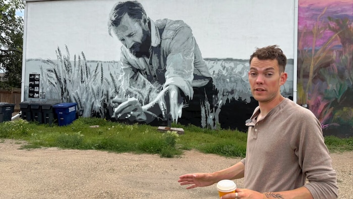 Andrew Robertson, pose devant la première fresque qu'il a réalisée à Shaunavon.