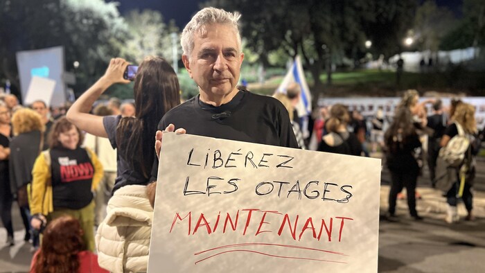 Un manifestant tient une affiche appelant à la libération des otages. 