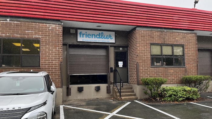 Une voiture grise stationnée devant le bâtiment de l'entreprise Friendlier.