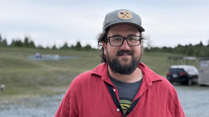 Maxime Dupuis pose sur le site de la Cité de l'Or, souriant.