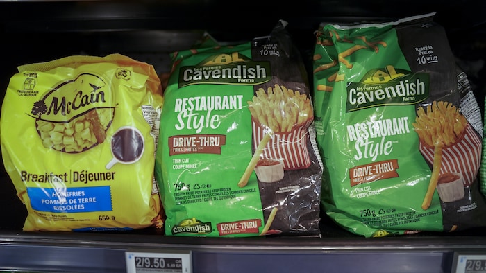 Des sacs de frites sur l'étagère d'un congélateur.