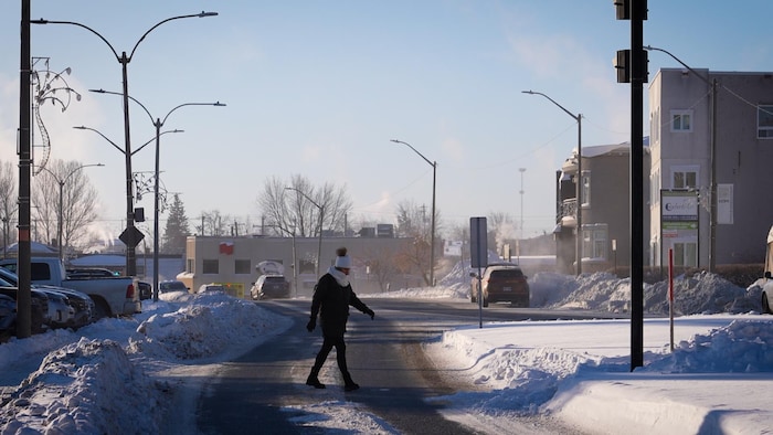 Un piétonne traverse une rue à Rouyn-Noranda pendant qu'une vague de froid frappe l'Abitibi-Témiscamingue.  