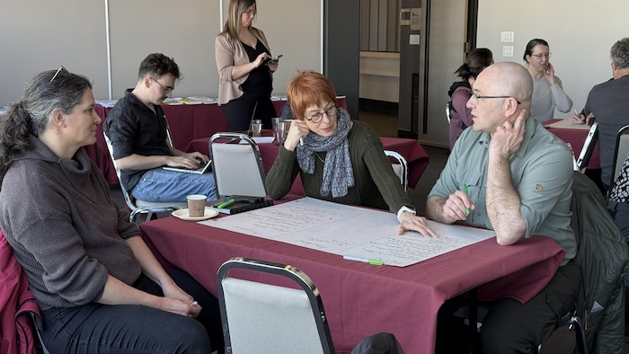 Des personnes assises à une table discutent.