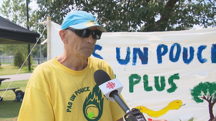 Portant un chandail sur lequel on peut lire le slogan « Pas un pouce de plus », Didier Delfolie-Noulin répond aux questions de Radio-Canada, dans le parc Jarry.