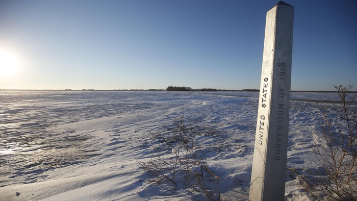 A road sign stands in the snowy, empty landscape just outside of Emerson, Man. Deepak Ahluwalia, a Canadian immigration lawyer working with asylum seekers in California, says human smuggling agents have no incentive to ensure the people they are smuggling end up safe on the other side of the border. 
