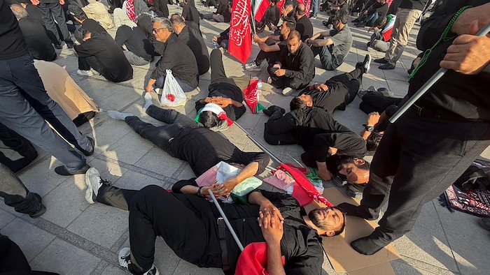 Des hommes sont couchés sur le sol, attendant le début de la cérémonie à Téhéran.