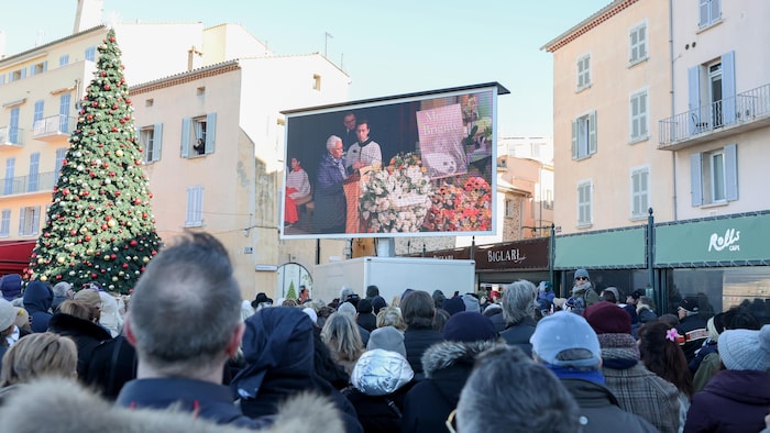Des gens regardent un écran géant.