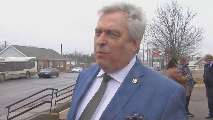 Un homme en entrevue à l'extérieur.