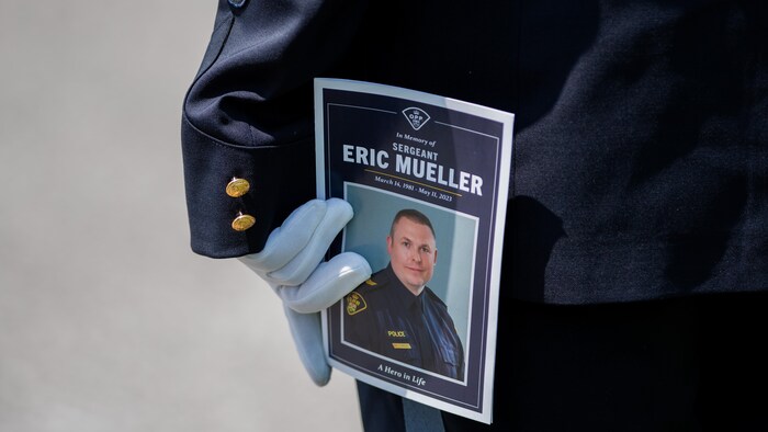 Un membre de la PPO tient une photo d'Eric Mueller dans ses mains.