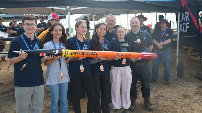Un groupe de jeunes et leur fusée avec l'astronaute Chris Hadfield.