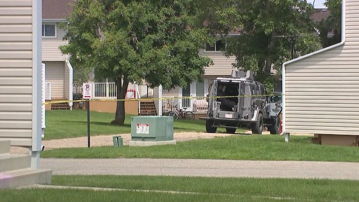 Un véhicule armé devant une maison.