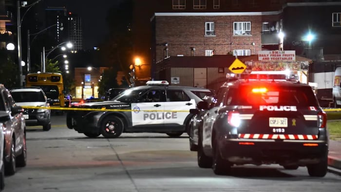 Des véhicules de police autour d'une scène de crime.