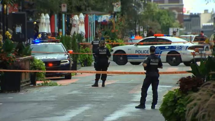 سيارتا شرطة وعناصر شرطة يضربون طوقاً أمنياً حول مسرح جريمة قتل في وسط مونتريال.