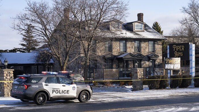 Une autopatrouille de la police de Toronto est garée devant un pub.