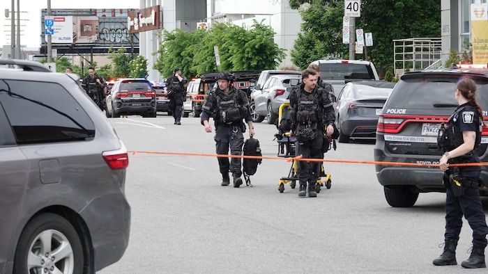 Des intervenants lourdement équipés transportent une civière.