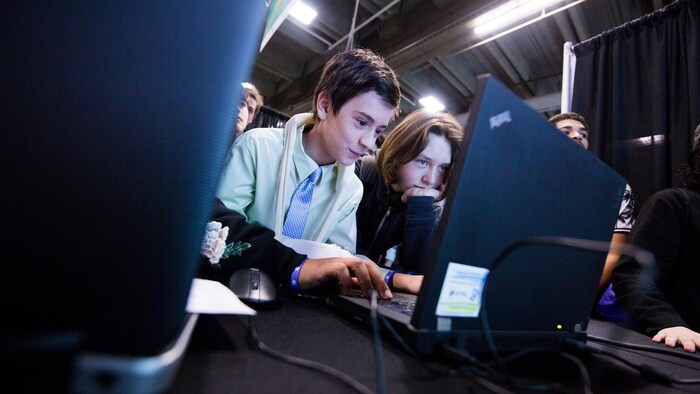 Deux jeunes jouent à un jeu sur un ordinateur. 