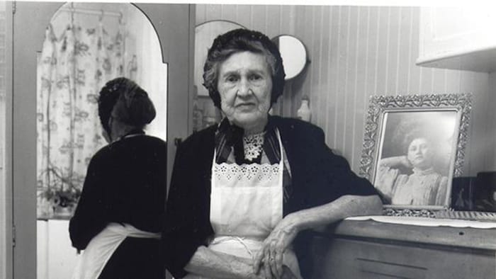 Photo d'une femme âgée dans sa chambre à coucher en 1970.