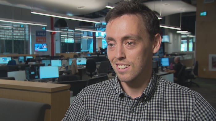 Le politologue Gabriel Arsenault en entrevue dans la salle des nouvelles de Radio-Canada Acadie.
