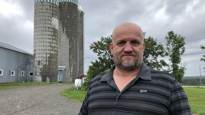 Gabriel Belzile devant une des silos de ferme à Saint-Clément.