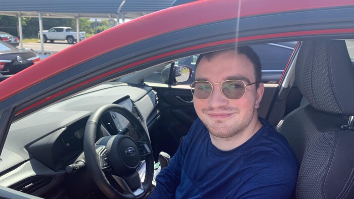 Gabriel LeBouthillier pose pour la photo, assis dans une voiture.