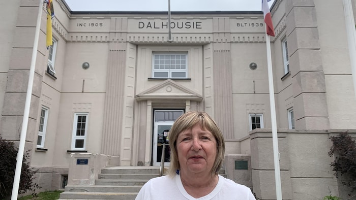 Une femme debout devant l'Hôtel de ville de Baie-des-Hérons