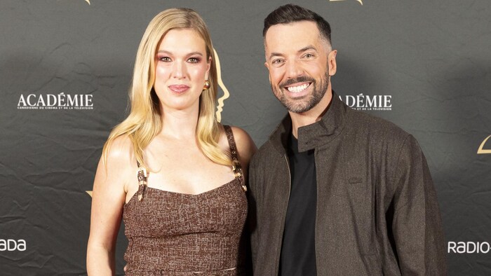 La femme et l'homme sourient sur le tapis rouge. 