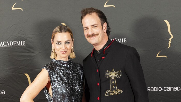 La femme et l'homme sourient sur le tapis rouge. 
