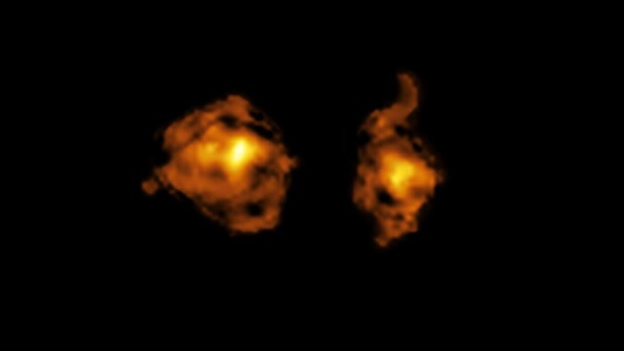 Les deux galaxies impliquées dans la collision cosmique ressemblent à deux nuages de feu sur un fond complètement opaque.