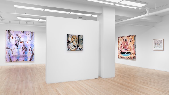 Des toiles sont exposées dans une galerie. 