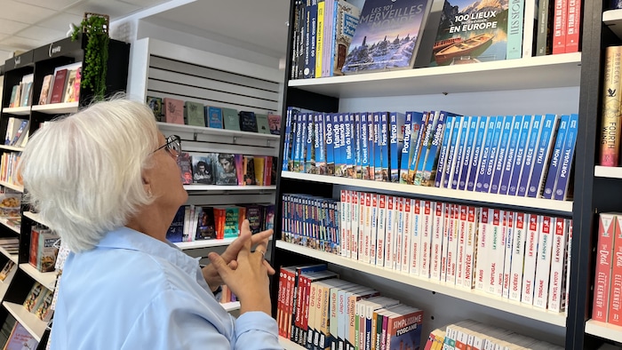 Mariane Côté regarde les livres de la section Voyage de la librairie.