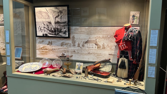 Une vitrine avec des objets et photos d'époque.