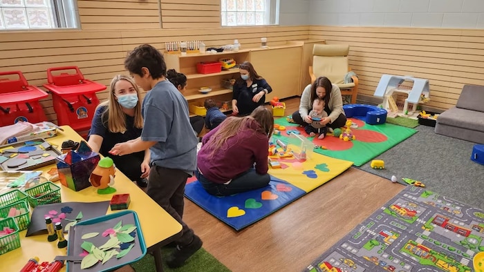 Une scène dans une garderie, alors que des enfants jouent avec des éducatrices.  