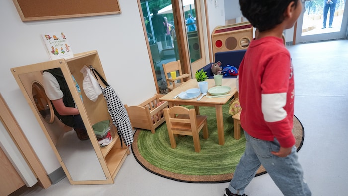 Un petit garçon marche dans une aire de jeu dans une garderie du YMCA, à North Vancouver, le 3 juillet 2025.