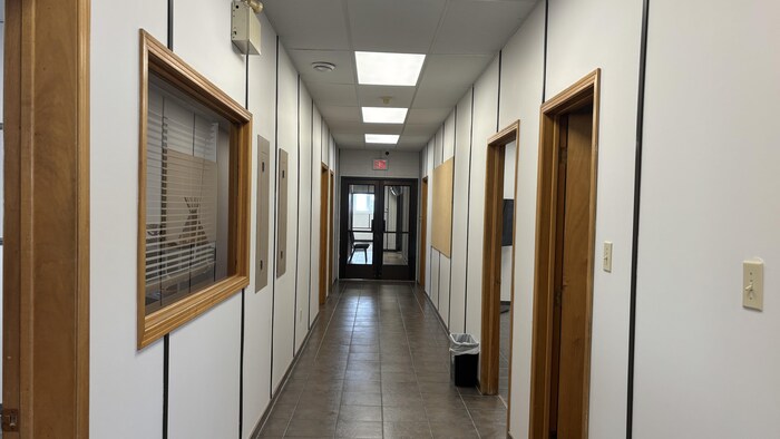 Un couloir vide avec des portes ouvertes.